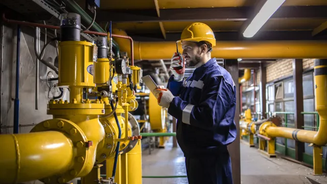 Fotografia de um técnico inspecionando tubulações